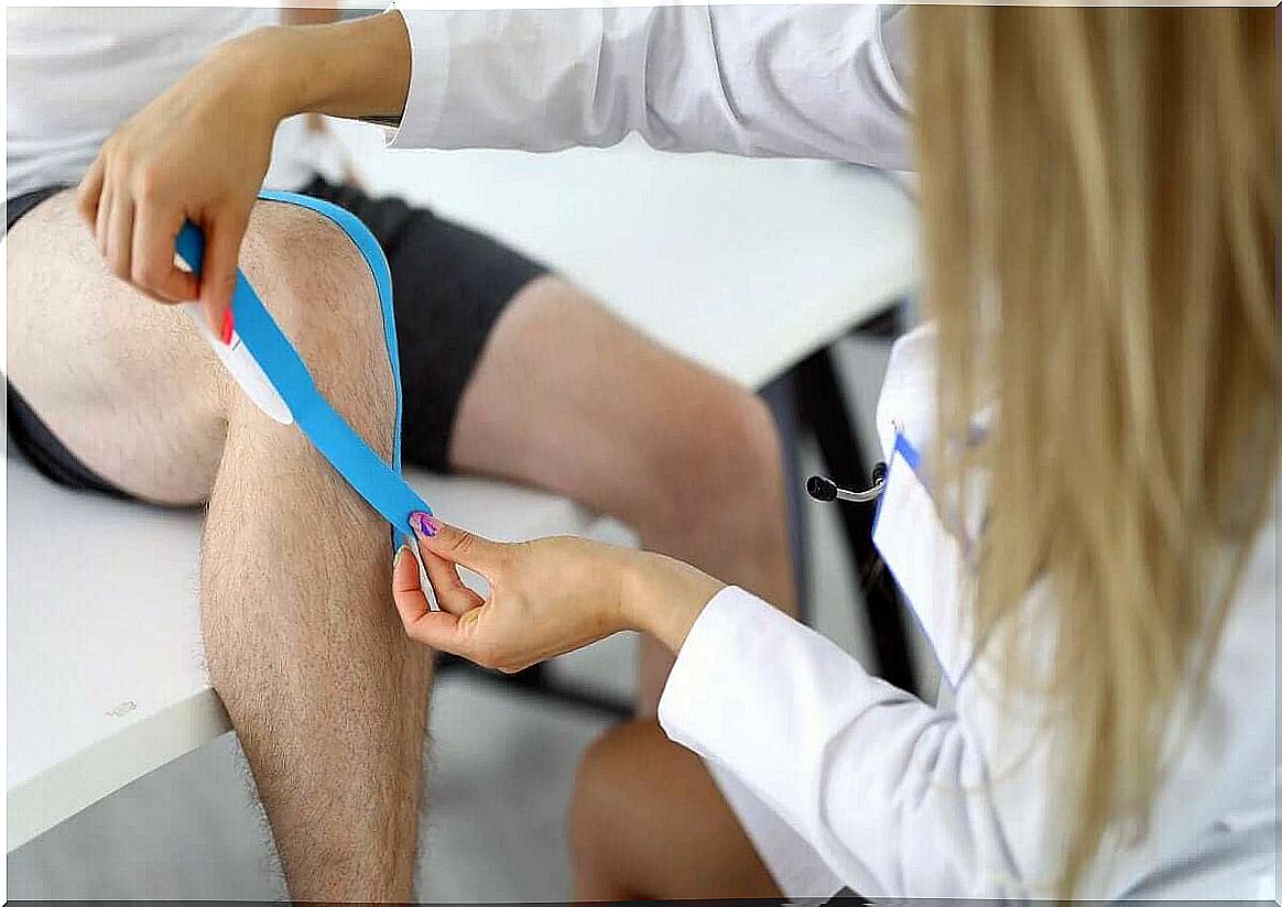 Doctor puts tape on knee