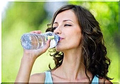 A woman drinks a bottle of water