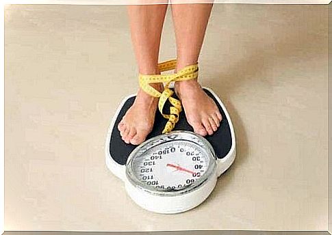 A woman stands on a scale with a measuring tape around her feet