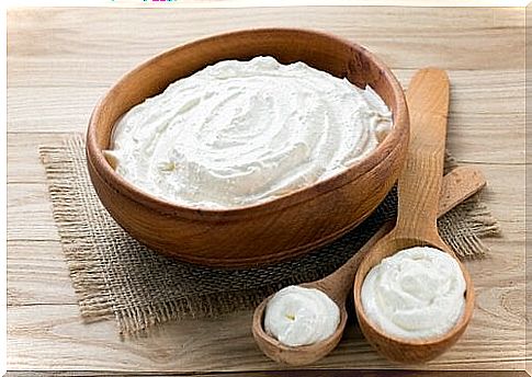 Wooden bowl and spoon with natural yogurt