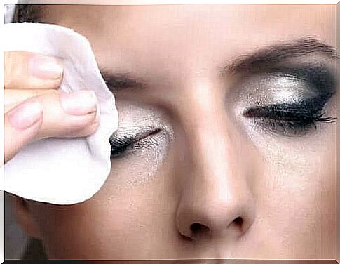 A woman removes her eyeshadow