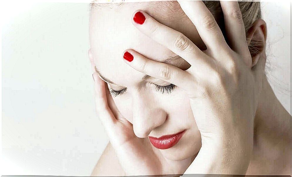 Woman holds her aching head